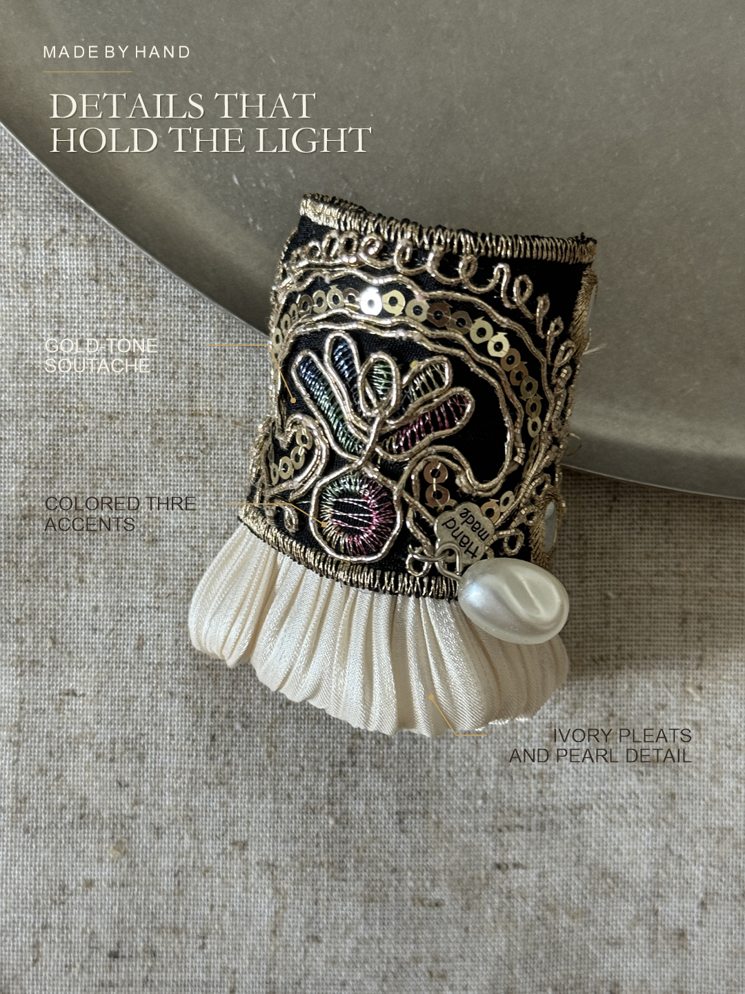 Close detail guide to the gold soutache, sequins, ivory pleats and pearl-look accent