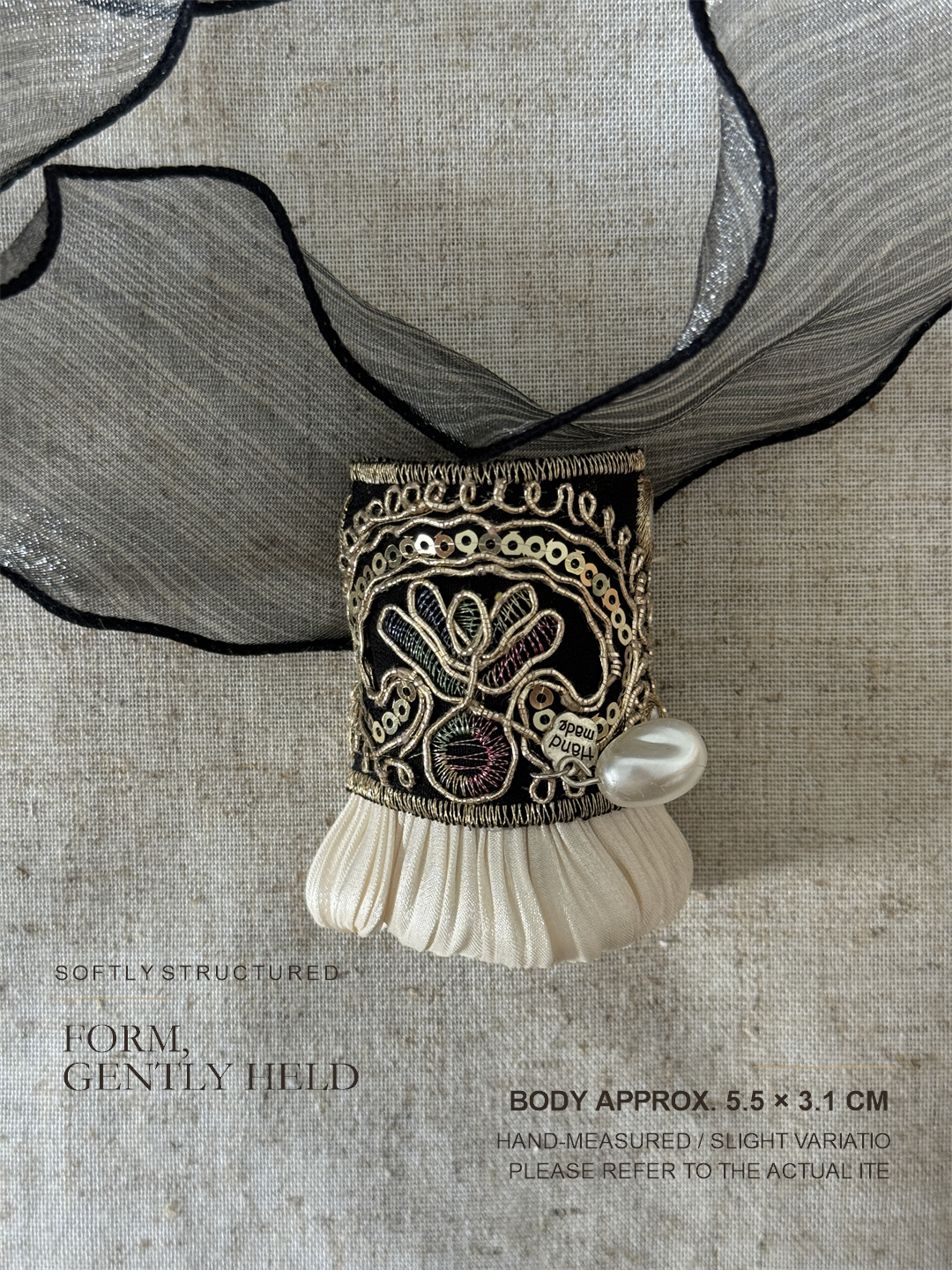 Midnight Gold Pleat shown with sheer charcoal organza detail and approximate 5.5 by 3.1 centimeter body size