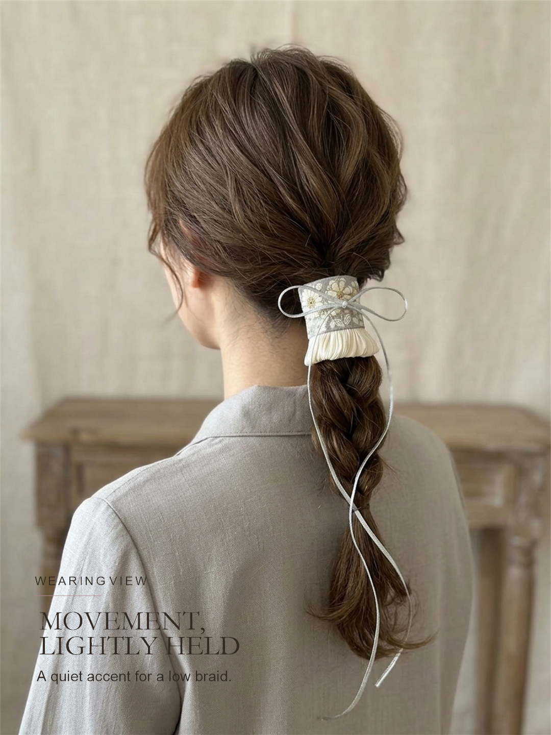 Silver Meadow Tie worn on a low braided ponytail with the fine cord falling freely