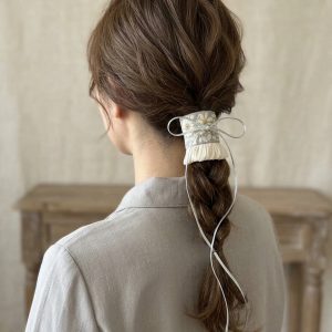 Silver Meadow Tie embroidered hair cuff worn on a low braided ponytail with a long silver-gray cord